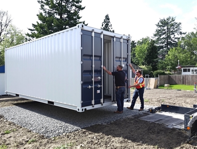 Crew confirming container placement and site access before delivery